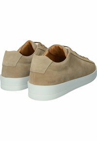 Beige Wildlederschuhe mit einer weißen Gummisohle und strukturierten Akzenten. Verfügt über flache Schnürsenkel und einen markierten Fersenbereich. Glatte Innenauskleidung.