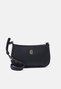 Borsa a tracolla in pelle blu navy con finitura testurizzata, ferrature dorate e tracolla regolabile. Presenta un logo sul davanti e una silhouette strutturata.