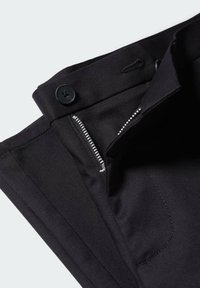 Schwarze Hose mit glatter Textur, Reißverschluss und auffälligem Knopfverschluss. Verfügt über eine Seitentasche mit sauberer Nahtdetail.