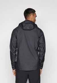 Moška črna vodoodporna jakna s kapuco, dolgimi rokavi, gladko teksturo in sproščenim krojem, zasnovana za uporabo na prostem.