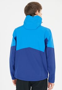 Blå och marinblå vindjacka med huva, med en geometrisk färgblockdesign och mjukt, lätt material.