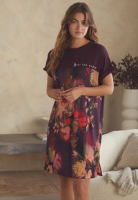 Jurkje met korte mouwen tot op de knie in diep bordeauxrood met een bloemrijke print. Gemaakt van zachte stof, met een ronde halslijn en zijslitten.