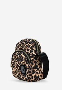 Mini mochila de tela con estampado de leopardo, que cuenta con dos compartimentos con cremallera, detalles en negro y un parche con el logo en la parte frontal.