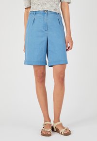 Pantalones cortos de denim azul claro con un corte ajustado, que cuentan con pliegues en la parte delantera y dobladillos enrollados. Cierre de botón sencillo y diseño minimalista.