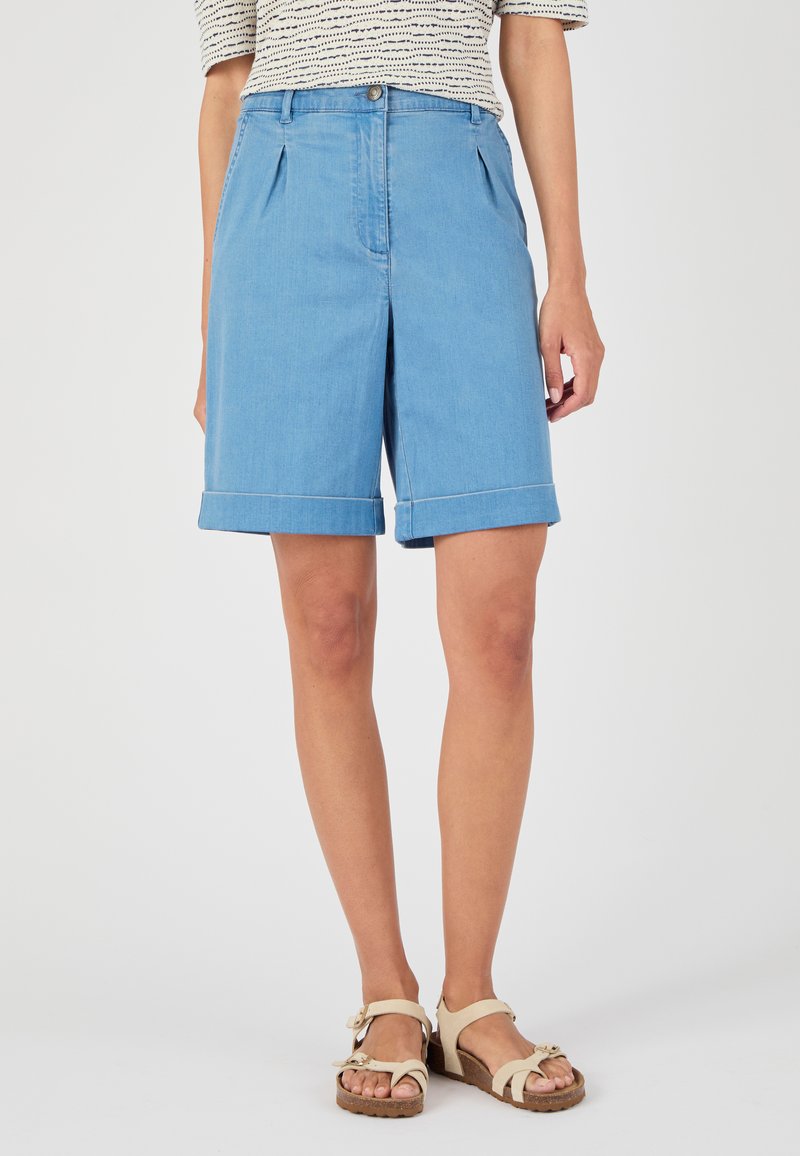 Pantalones cortos de denim azul claro con un corte ajustado, que cuentan con pliegues en la parte delantera y dobladillos enrollados. Cierre de botón sencillo y diseño minimalista.