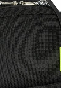 Mochila negra texturizada con un zipper suave, etiqueta de neón verde en contraste y material duradero con un tejido patrón.
