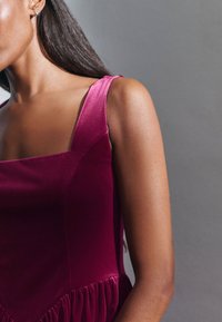 Bordeaux-velours Kleid mit quadratischem Ausschnitt und breiten Trägern, weichem Material und gerafften Details an der Taille.