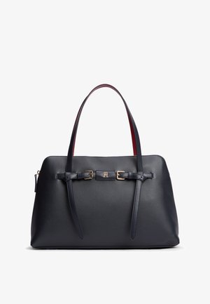 Borsa in pelle nera con doppie tracolle, dettagli con fibbie e piccolo logo metallico centrale su sfondo bianco.