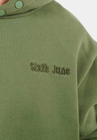 Felpa oversize verde realizzata in tessuto morbido. Caratterizzata da un cappuccio con bottoni a pressione verdi e "Sixth June" ricamato in un font verde scuro.