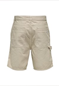 Bermudas de color beige con un corte relajado, hechas de una tela resistente. Presentan dos bolsillos de parche en la parte trasera y costuras reforzadas.