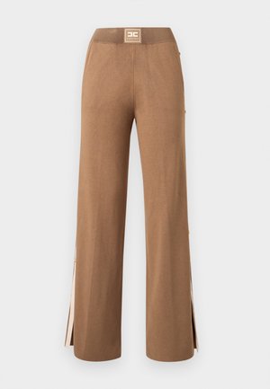 Pantalon large marron à texture lisse, doté d'une taille haute et de fentes latérales, agrémenté de petits boutons dorés.