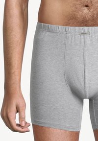 Boxer in cotone grigio con design aderente. Texture morbida, cintura elastica e una tasca frontale prominente per il supporto.