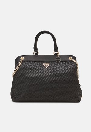 Černá tkaná kabelka s dvojitými uchy, zlatými řetízkovými ramínky a malým kulatým zlatým odznakem značky na jednoduchém pozadí.