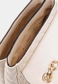 Borsa a tracolla in pelle bianca con texture trapuntata, due scomparti interni e finiture in oro. Foderata in tessuto beige.