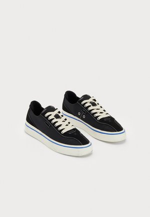 Sneakers neri in tela con lacci crema e dettagli blu. Suola in gomma bianca con dettagli di cucitura e design snello.