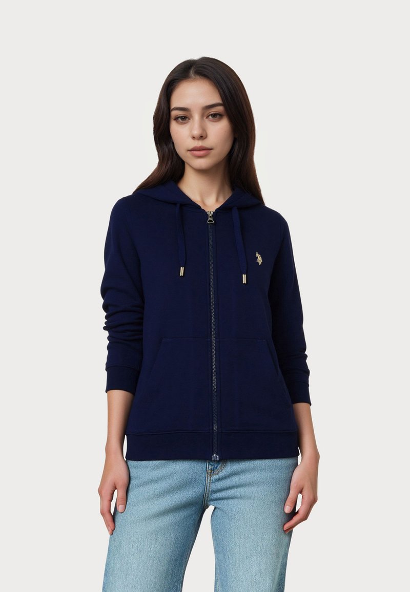 Tengerészkék zipzáras kapucnis pulóver puha anyagból, elülső zsebbel, húzózsinóros kapucnival és arany színű fém kiegészítőkkel. Diszkrét logó a mellkason.