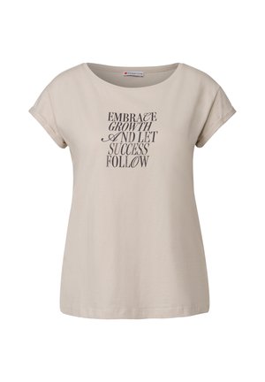 Beige bomulls t-shirt med en rundad halsringning, korta uppvikta ärmar och tryckt svart text: "OMFÖRDA UTVECKLING OCH LÅT FRAMGÅNGEN FÖLJA."