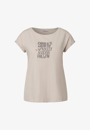 Beige Baumwoll-T-Shirt mit Rundhalsausschnitt, kurzen, umgekrempelten Ärmeln und schwarzem Drucktext: "UMFASSE WACHSTUM UND LASSEN DEN ERFOLG FOLGEN."