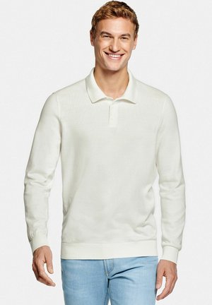 Witte poloshirt met lange mouwen van zachte stof, met een klassieke kraag en geribbelde manchetten, gecombineerd met lichtblauwe spijkerbroek.