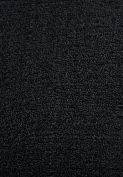 Υφασμάτινο μαύρο με υφή, με βαρύ, υφαντό ύφος. Η επιφάνεια έχει ελαφρώς τραχύ άγγιγμα, παρουσιάζοντας ομοιόμορφο χρώμα και μοτίβο.