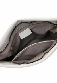 Borsa in pelle bianca con chiusura a zip, caratterizzata da una texture liscia e un interno grigio. Include una piccola tasca e un'etichetta in pelle.
