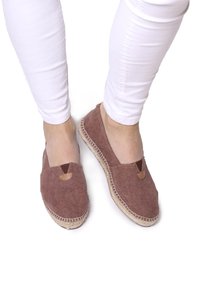 Espadrillas in tela marrone con punta rotonda, dettagli elasticizzati sui lati e suola in juta. Tessuto testurizzato con cuciture a contrasto.