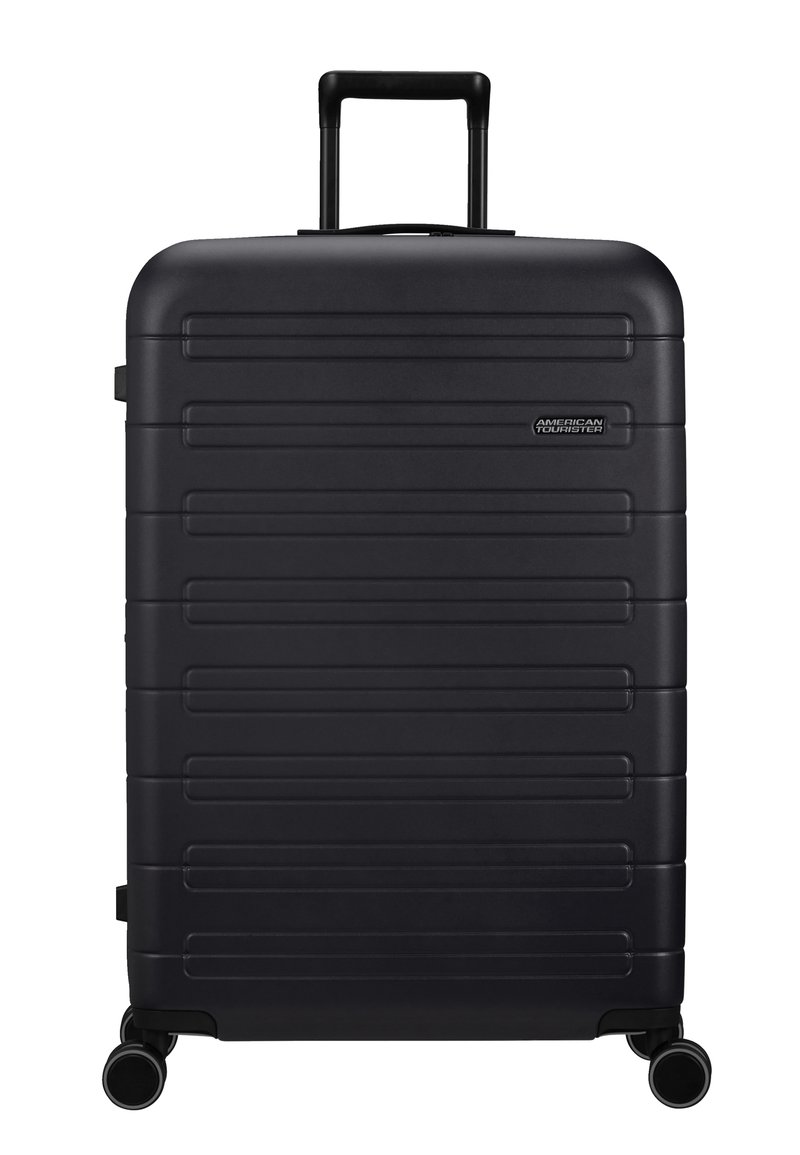Schwarzer Polycarbonat-Koffer mit horizontalem Rippendesign, ausziehbarem Griff und vier Rädern für Mobilität. Mit eingeprägtem Markenlogo.