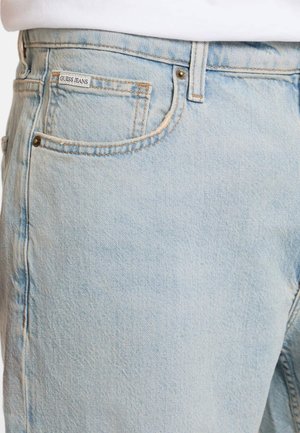 Jasnoniebieskie dżinsy z wyblakłym wykończeniem, z małą metką z logo, pięcioma kieszeniami, metalowymi nitami oraz klasycznym prostym krojem nogawek.