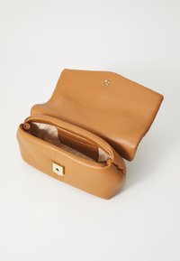 Sac à main en cuir tan avec un design structuré, fermoir en métal doré et doublure en tissu doux, comprenant un haut ouvert et une texture lisse.