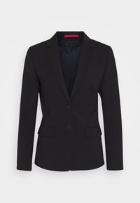 Svart kavaj med skräddarsydd design, enkelknäppt knäppning, två framfickor och ett slätt, texturerat tyg. Fodrad inredning.