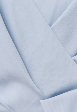 Close-up van lichtblauwe stof met een gladde, strak geweven textuur en zachte plooien die diagonale en gebogen lijnen creëren.