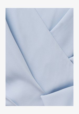 Close-up van lichtblauwe stof met een gladde, strak geweven textuur en zachte plooien die diagonale en gebogen lijnen creëren.