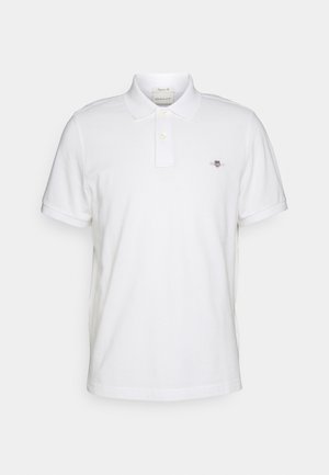 Witte katoenen polo met een klassieke kraag, voorzien van twee knopen en een klein geborduurd logo op de linkerkant van de borst. Korte mouwen.