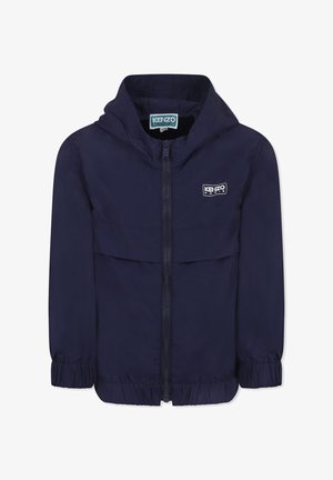 Giacca blu navy con cappuccio, chiusura con zip, polsini elasticizzati e un patch con logo sul petto. Tessuto leggero e dalla texture liscia.