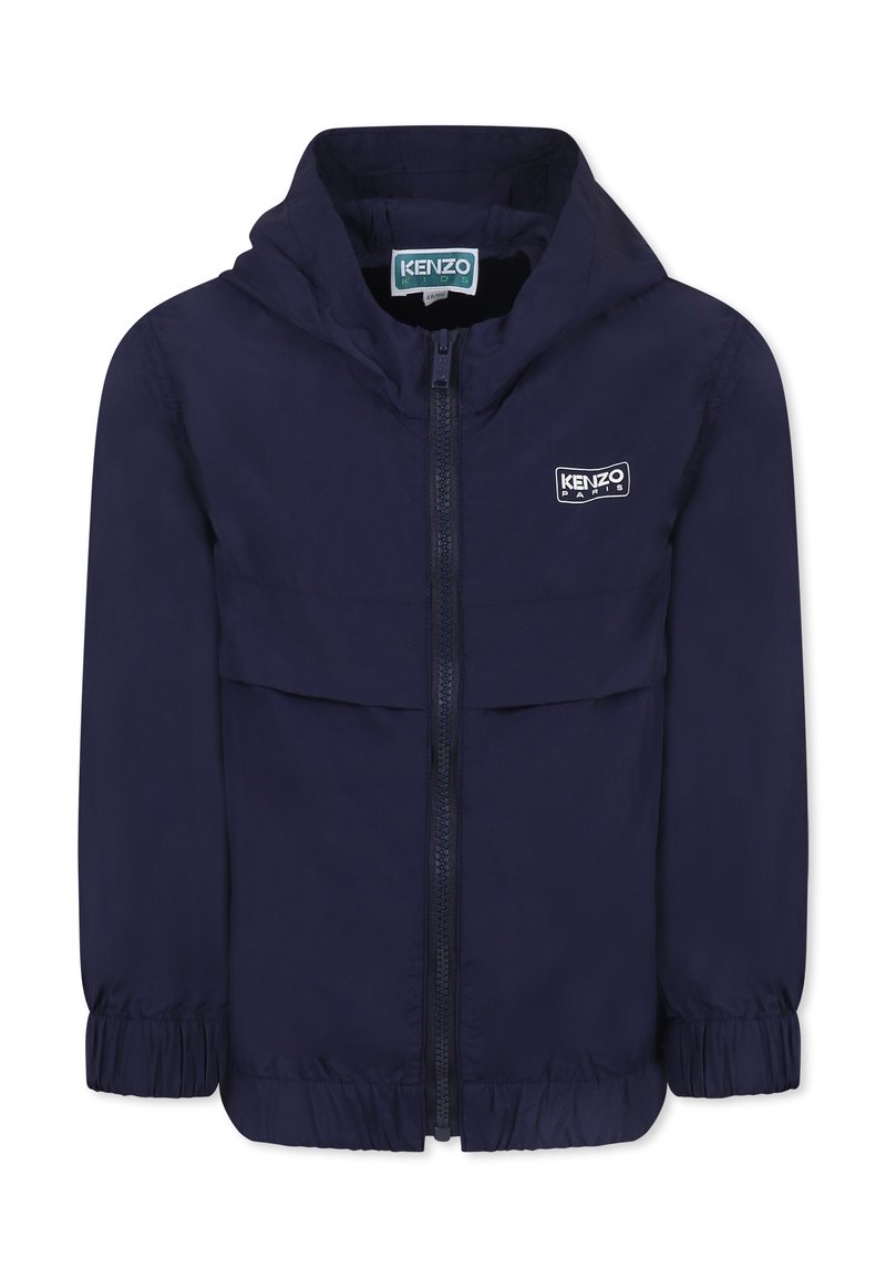 Giacca blu navy con cappuccio, chiusura con zip, polsini elasticizzati e un patch con logo sul petto. Tessuto leggero e dalla texture liscia.