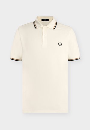 Crèmekleurig poloshirt met korte mouwen, zwarte en bruine streepdetails op de kraag en mouwen, twee knopen plooi en klein zwart lauwerkranslogo.