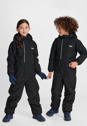 Zwarte waterdichte sneeuwpakken met capuchons, ritssluitingen, elastische manchetten en zakken, gedragen door twee kinderen. Handschoenen en schoenen zijn blauw.