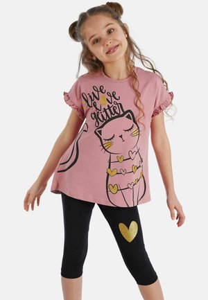 Camiseta de algodón rosa con mangas acampanadas, que presenta un gráfico de un gato negro y acentos de purpurina dorada. Leggings negros con detalle de corazón dorado.