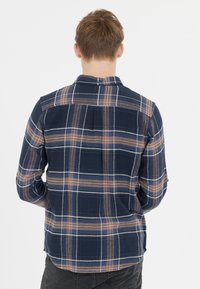 Geruite overhemd in marineblauw, oranje en witte kleuren; met knoopsluiting, lange mouwen, rugplooi detail, zachte stof met een licht getextureerde afwerking.