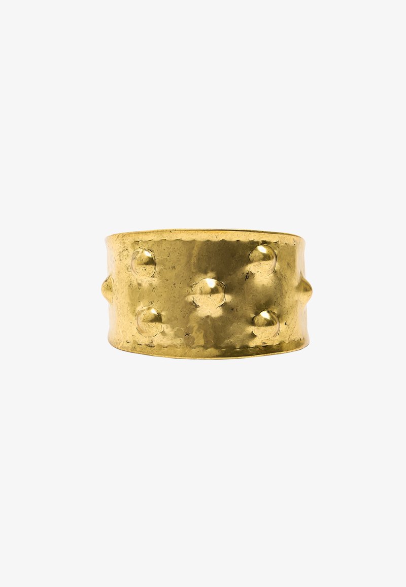 Złoty metalowy pierścień o fakturowanej, młotkowanej powierzchni, z uniesionymi, zaokrąglonymi akcentami równomiernie rozmieszczonymi wokół obrączki.
