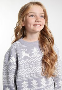 Světle fialový pletený svetr s bílými soby a stromy v fair isle vzoru. Trochu oversize, s žebrovaným výstřihem.
