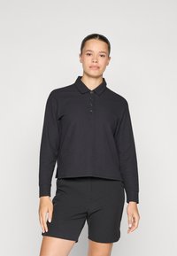 Black long-sleeve polo top with a buttoned placket and a flat collar, paired with black shorts. Smooth fabric, relaxed fit.