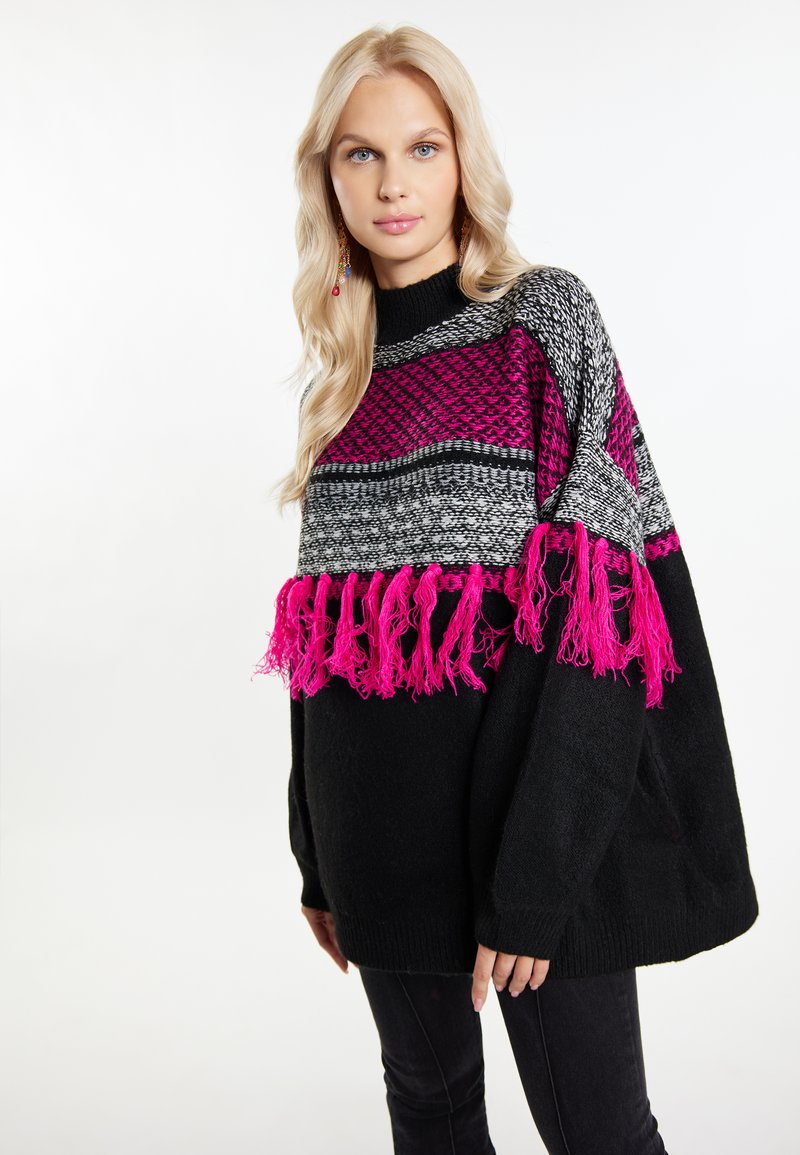 Maglione oversize nero con motivi geometrici rosa e grigi. Presenta dettagli in frange sull'orlo e un design a maglia testurizzata.