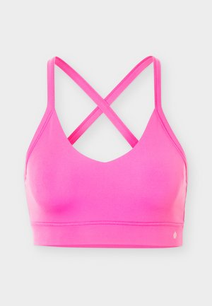 Brassière de sport rose vif avec des bretelles croisées dans le dos et un petit logo blanc en bas à droite, présentée sur un fond clair uni.