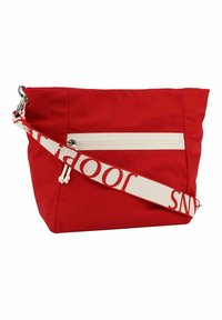 Rote Stoffschultertasche mit einer cremefarbenen Reißverschluss-Tasche und einem verstellbaren cremefarbenen Tragegurt, der roten Text aufweist. Glatte Textur mit einer lässigen Form.