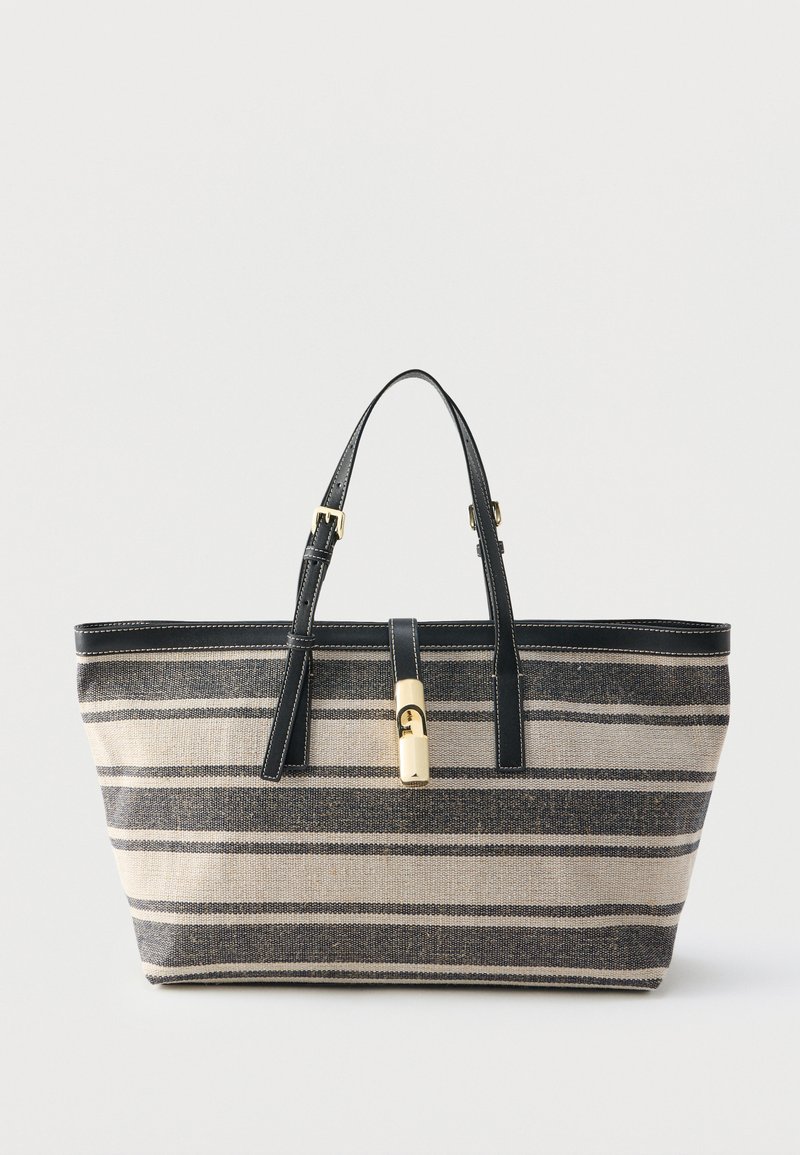 Τσάντα ώμου με μπεζ και μαύρες ρίγες, μαύρες δερμάτινες λαβές και κούμπωμα με χρυσό τόνο, σε λευκό φόντο.