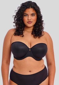 Soutien-gorge noir sans bretelles avec bonnets moulés, texture lisse, soutien avec armature et un petit accent métallique au centre.