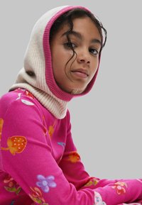 Heller rosa Pullover mit strukturiertem Strick, der bunte Blumenmuster zeigt. Die Kapuze ist cremefarben mit einem pinken Rand, der das Gesicht umrahmt.