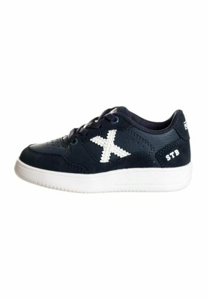 Zapatillas de deporte azul marino de cuero con acentos blancos. Presenta una superficie texturizada, punta redonda, diseño de cordones y suela de goma.