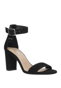 Zwarte suede hoge hak sandaal met een enkelbandje en een zilveren gesp. Heeft een open teenontwerp en een blokhak voor stabiliteit.